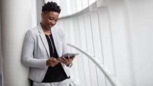 Nainen käyttää tablettia liiketilassa