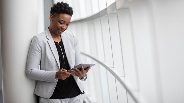Nainen käyttää tablettia liiketilassa